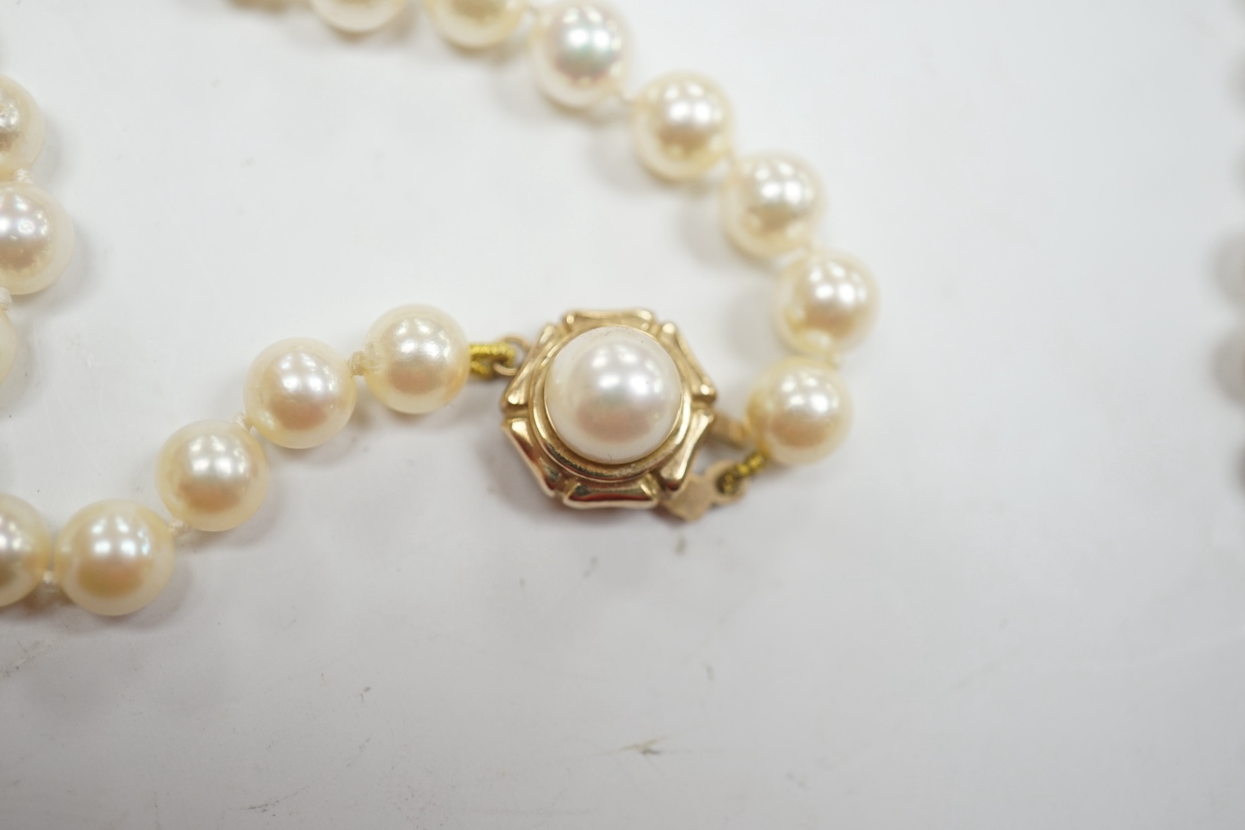 A modern twin strand cultured pearl bracelet, with 14k clasp, 17.5cm, together with two single strand cultured pearl necklaces, with yellow metal clasps. Condition - poor to fair